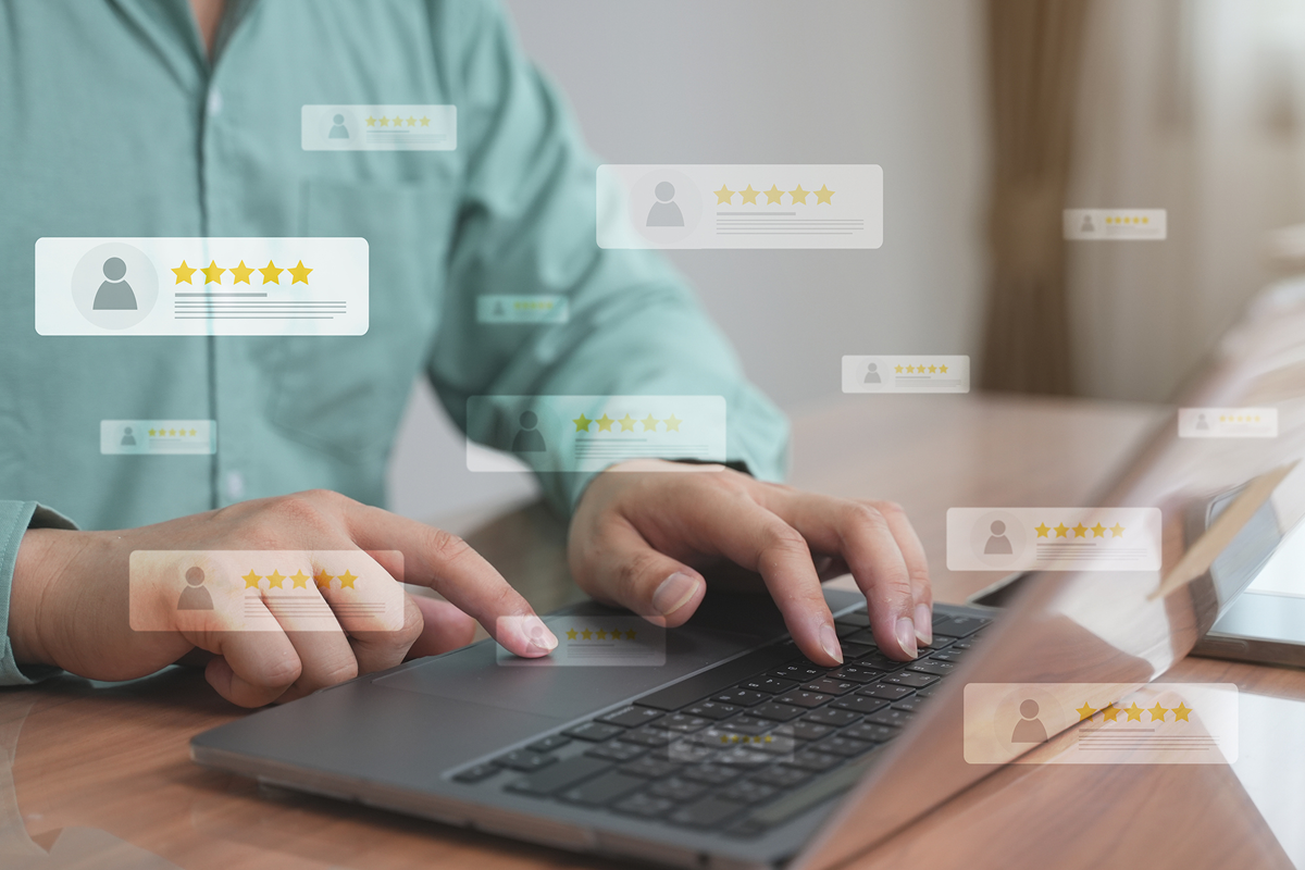 Person typing on laptop with online reviews